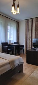 格绍特兰西瓦尼亚公寓及Spa的一间卧室配有一张床,客厅配有钢琴
