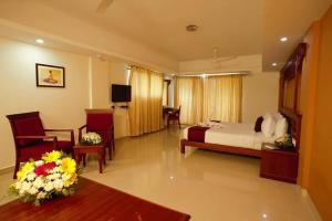 阿勒皮Haveli Backwater Resort的酒店客房带一张床、一张桌子和椅子