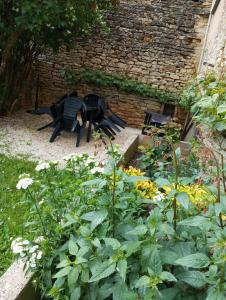 VisernyGîte à la ferme的一座花园,里面设有黑色长凳和一些鲜花