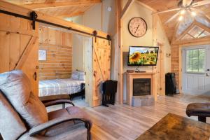 EldonThe Eldon Cabin Experience的客厅设有壁炉、床和时钟