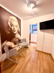 巴塞罗那Borne rooms的客厅配有桌子和一幅女画