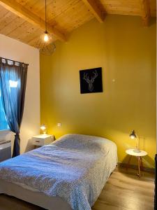 勒沙托多莱龙Boinot Lodge的一间卧室设有一张床和黄色的墙壁
