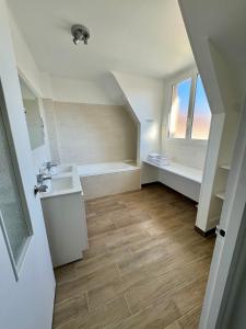 滨海圣奥班Le Clos Normand的浴室配有盥洗盆和浴缸。