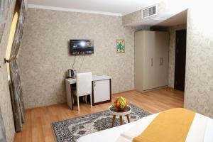 巴库Nemi Hotel Baku的一间卧室配有一张床、一张桌子和一张书桌