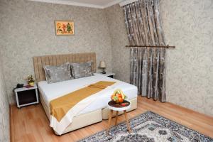 巴库Nemi Hotel Baku的一间卧室配有一张床和一张桌子,上面放着一碗水果