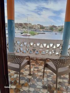 阿斯旺NiLe ViEW RANA NUbian Guest HOUES的阳台上配有两把椅子,享有水景