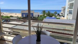 波尔蒂芒Miramar Apartments的阳台配有桌子,享有海滩美景