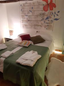 ValdealgorfaMusas Gastro Casa Rural的一间卧室配有绿床和毛巾