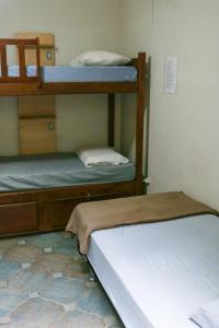 纳塔尔Get Up Hostel的一间带两张双层床的卧室,铺有瓷砖地板。