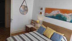 波尔蒂芒Miramar Apartments的卧室配有一张床,墙上挂有绘画作品