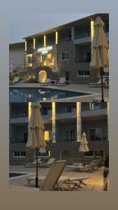 奈德里3 Island View Hotel的大楼前的带椅子和遮阳伞的游泳池