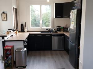 阿让Maison cosy au calme avec jardin的厨房配有黑色冰箱和窗户。