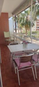罗达德瓦拉ENCANTADOR apartamento frente a la playa de Bara的门廊上的一张白色桌子和两把椅子
