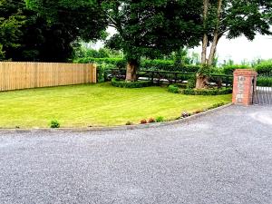 纳文White Quarry Hse Quarry Road的一个带栅栏、长凳和草地的院子