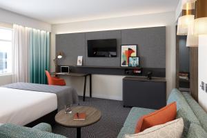 第戎Holiday Inn Dijon Sud - Longvic, an IHG Hotel的配有一张床和一张书桌的酒店客房