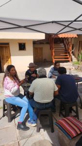 库斯科Munay Cusco的一群人坐在桌子上,在伞下