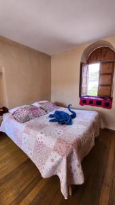 库斯科Munay Cusco的一间卧室配有一张带粉色毯子的床和窗户。