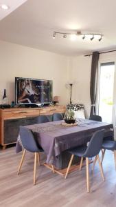 阿让Maison cosy au calme avec jardin的客厅配有桌椅和电视