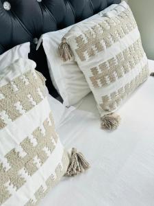 米德兰Gallagher Midrand BnB的一张白色的床,上面有两个枕头