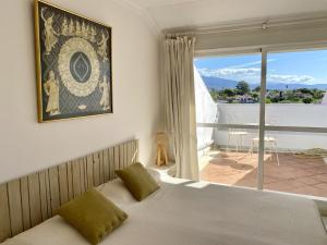 马贝拉Duplex vistas al golf Guadalmina Marbella的一间卧室设有一张床和一个大窗户