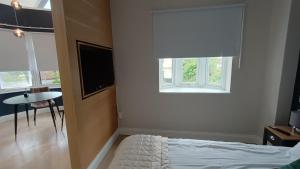 哈罗London Studios and Suites的一间卧室设有一张床、一个窗口和一张桌子