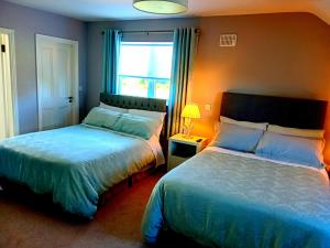 纳文White Quarry Hse Quarry Road的一间卧室设有两张床和窗户。