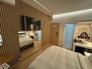 雅典米拉达酒店的一间酒店客房,配有一张床和一台墙上的电视