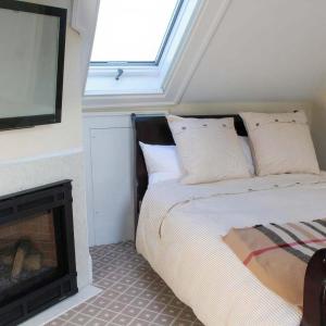 埃利科特城Mary's Land Farm的一间卧室设有一张位于壁炉旁的床。