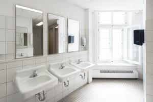 魁北克市Auberge Internationale de Quebec - HI CANADA的白色的浴室设有两个盥洗盆和窗户。