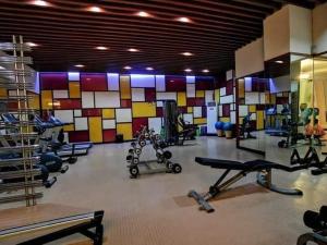 马尼拉CP19P TWINBED COZY ROOM Near at Venice Mall的健身房,配有多台机器和五颜六色的墙壁