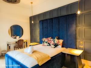 珀斯The Lovat Hotel的一间卧室设有一张蓝色墙壁的大床