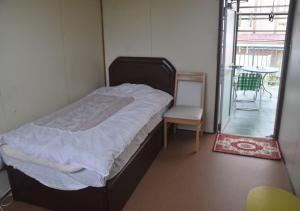 德之岛Guest House Minatoya Tokunoshima - Vacation STAY 01034v的一间卧室配有一张床、一把椅子和一张桌子