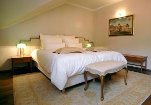普图伊Hotel Mitra, Story Hotels的卧室配有一张带两张桌子的大型白色床