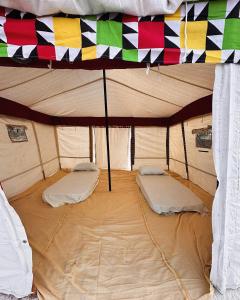 Kafr Abu HabhabCaves Camp Matrouh的帐篷内有两张床