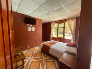 巴尼奥斯Playita Salomon的一间卧室设有一张床、一个窗口和一台电视。