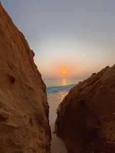 Kafr Abu HabhabCaves Camp Matrouh的岩石海滩上日落