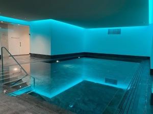米施泰尔赫尔维蒂酒店的室内的游泳池,有蓝色的灯光