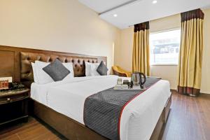新德里Grand Empire Suites By Delhi Airport的酒店客房设有床和窗户。