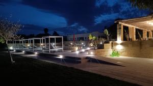 奥特朗托Tenuta I Quattro Venti的一座晚上在建筑前方的带灯光的庭院