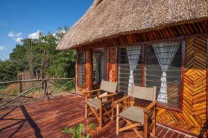 KakumbiNjobvu Safari的小屋设有躺椅和茅草屋顶