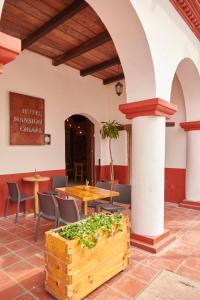 恰帕德科尔索Hotel Mansión Chiapa的一间带桌椅和桌子的餐厅
