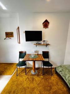 布莱德Slovenian House Vida的一间带桌椅和电视的用餐室