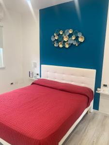 圣焦万尼泰亚蒂诺La Bussola Airport Affitta Camere的一间卧室设有红色的床和蓝色的墙壁