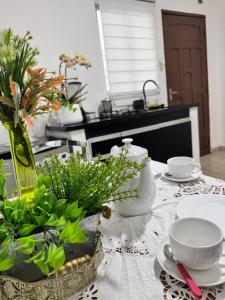 圣克鲁斯Acogedor independiente-Casa JH A的桌上放有盘子,碗和花