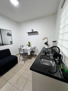 圣克鲁斯Acogedor independiente-Casa JH A的厨房以及带水槽和沙发的客厅。