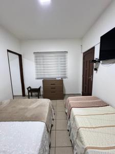 圣克鲁斯Acogedor independiente-Casa JH A的酒店客房设有两张床和一台平面电视。