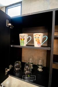 库奥蒂特兰伊斯卡伊A12 Full Suite ‖ Mini Dept at Plaza Acequia的架子上两个咖啡杯和玻璃杯