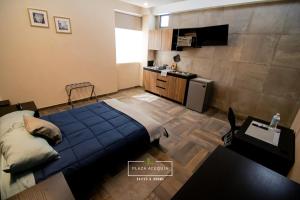 库奥蒂特兰伊斯卡伊A12 Full Suite ‖ Mini Dept at Plaza Acequia的一间带蓝色床的卧室和一间厨房