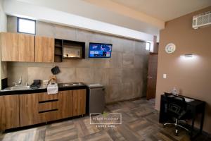 库奥蒂特兰伊斯卡伊A12 Full Suite ‖ Mini Dept at Plaza Acequia的一个带台面和水槽的厨房和墙上的电视