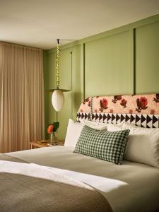 檀香山Wayfinder Waikiki的一间卧室设有一张大床和绿色的墙壁